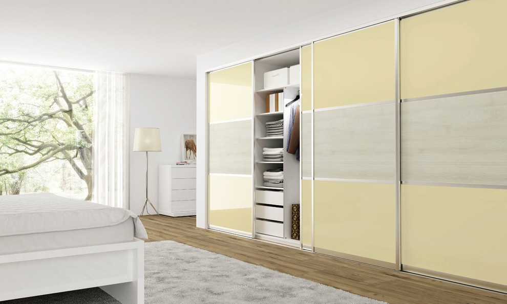 На фото: шкаф в нише среднего размера в стиле модернизм с плоскими фасадами и желтыми фасадами с