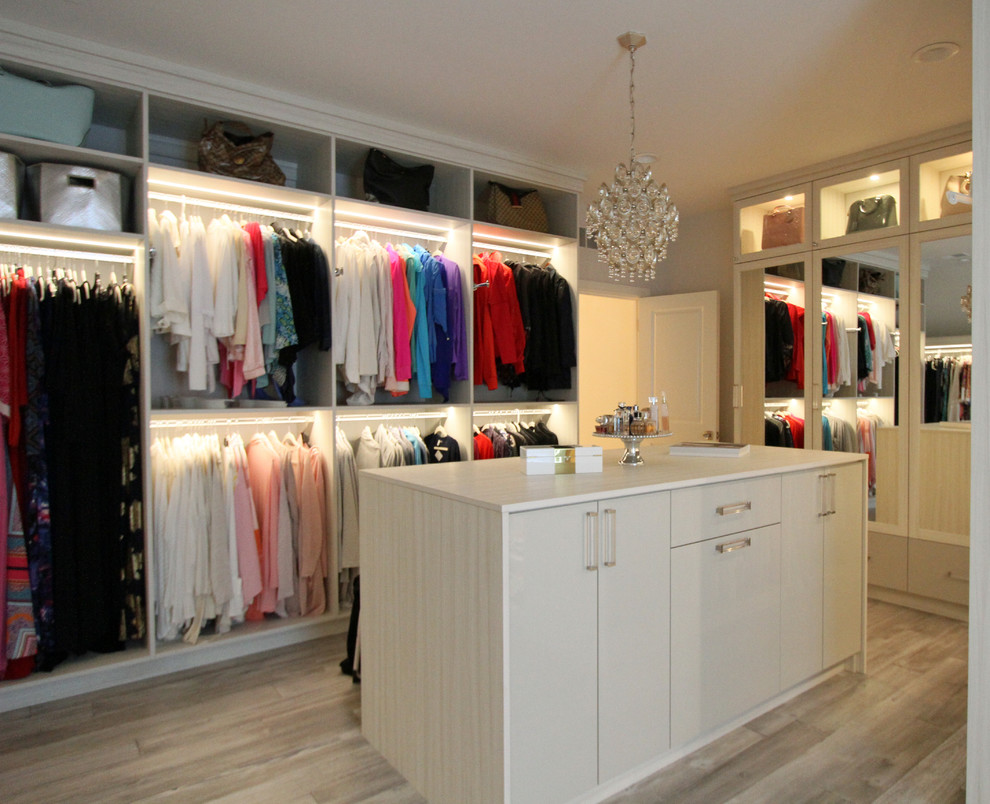 Large transitional women's light wood floor and gray floor walk-in closet photo in Detroit with glass-front cabinets and light wood cabinets