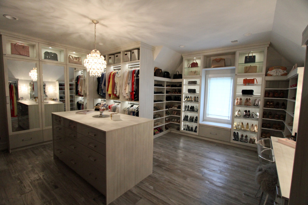Inspiration for a large traditional walk-in wardrobe for women in Detroit with glass-front cabinets, light wood cabinets, light hardwood flooring and grey floors.