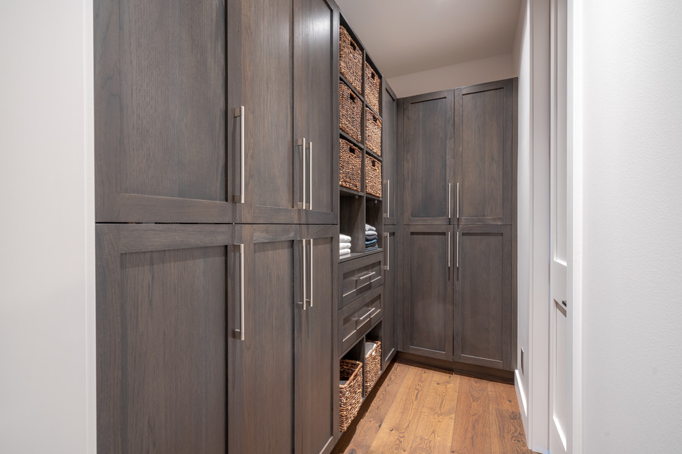 Foto de armario vestidor unisex minimalista de tamaño medio con armarios estilo shaker, puertas de armario marrones, suelo de madera en tonos medios y suelo marrón