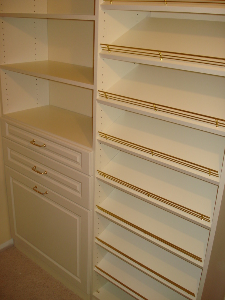 Inspiration for a large traditional gender neutral walk-in wardrobe in Boston with raised-panel cabinets, beige cabinets and carpet.