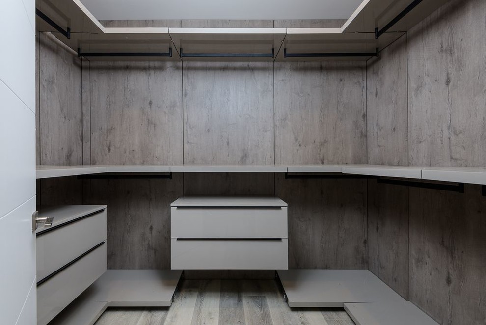 Inspiration för moderna walk-in-closets för könsneutrala, med vita skåp, ljust trägolv och grått golv