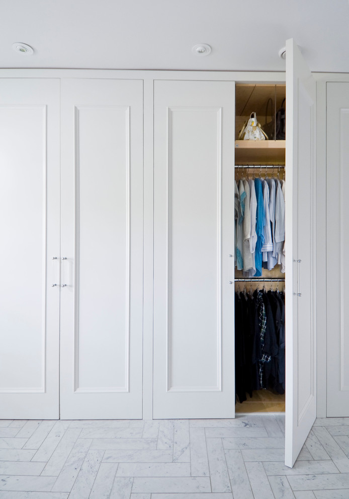 Inspiration pour un grand dressing room traditionnel pour une femme avec un placard avec porte à panneau encastré, des portes de placard blanches et un sol en marbre.