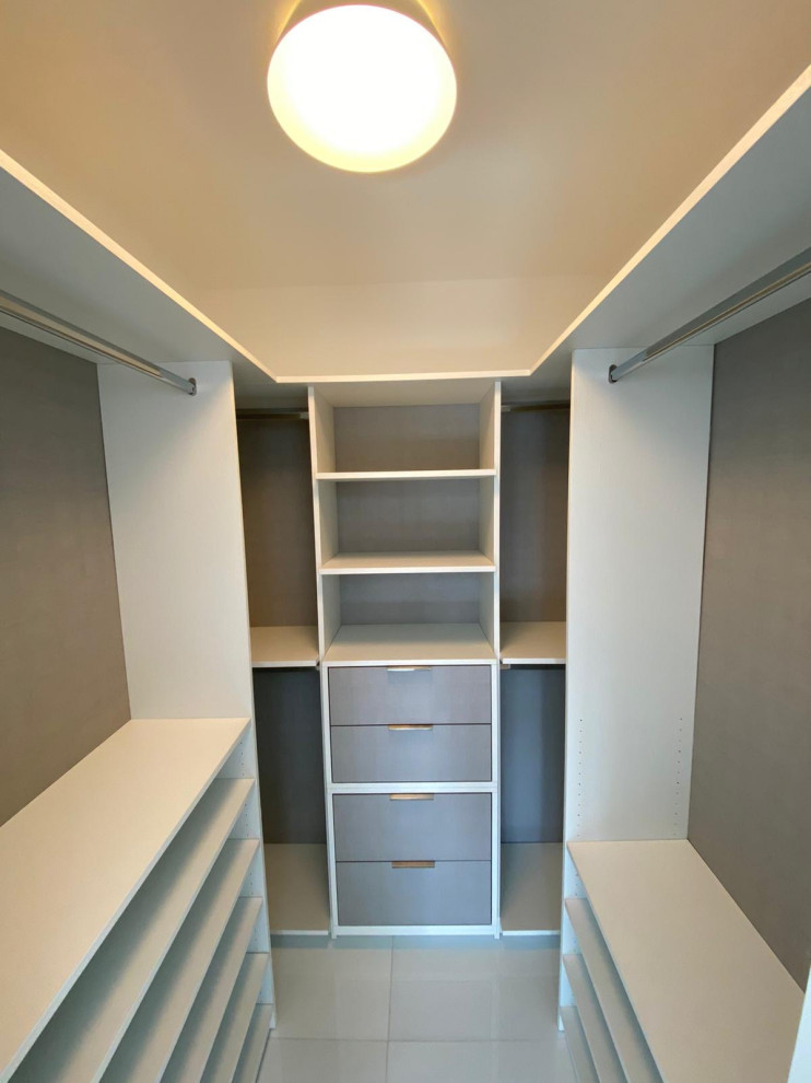 Diseño de armario vestidor unisex pequeño con armarios abiertos, puertas de armario de madera clara y suelo de baldosas de cerámica