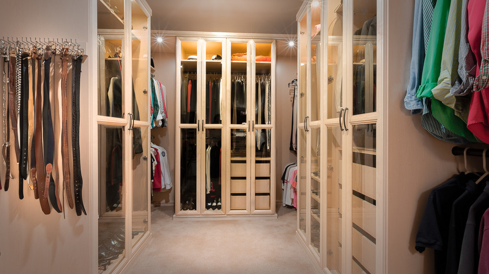 Photo of a medium sized classic gender neutral walk-in wardrobe in Los Angeles with glass-front cabinets, light wood cabinets and carpet.