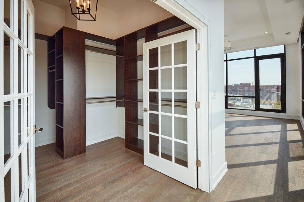 Foto de armario vestidor unisex contemporáneo de tamaño medio con armarios con paneles lisos, puertas de armario de madera en tonos medios, suelo de madera en tonos medios y suelo marrón