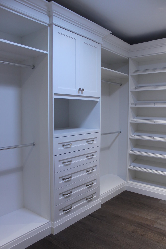 Idee per una cabina armadio unisex classica di medie dimensioni con ante lisce, ante bianche e pavimento in legno massello medio