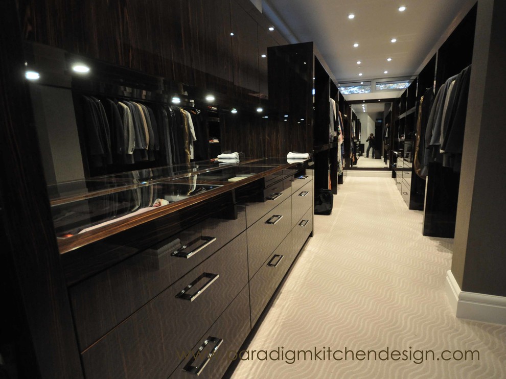 Geräumiges Modernes Ankleidezimmer mit Ankleidebereich, flächenbündigen Schrankfronten, dunklen Holzschränken und Teppichboden in Vancouver