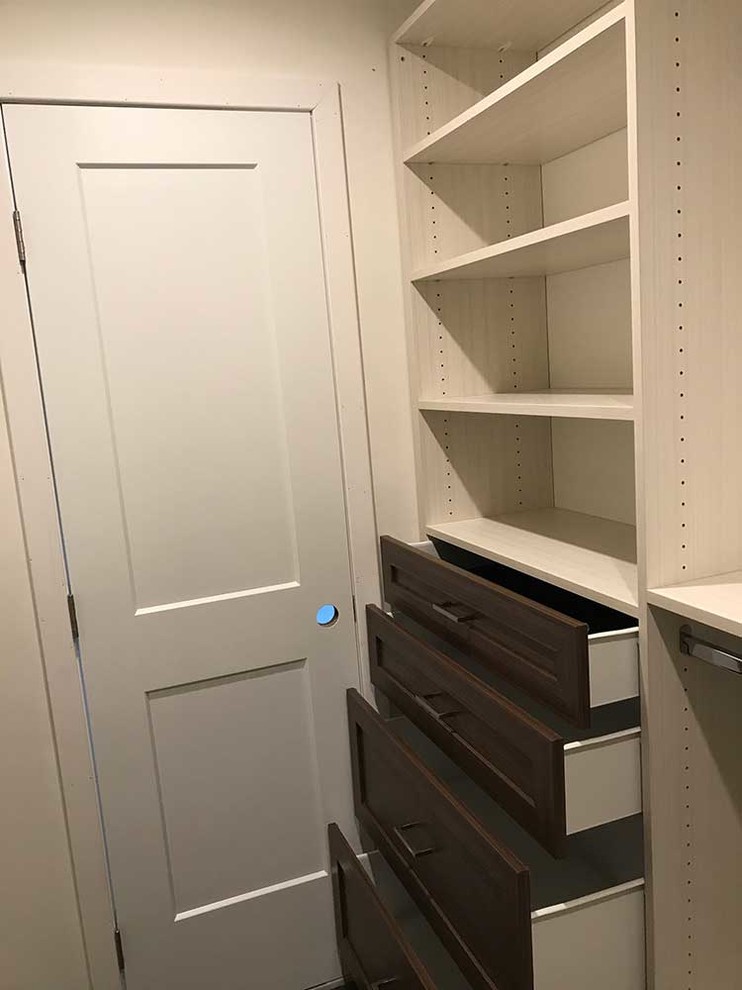 Foto de armario vestidor unisex contemporáneo pequeño con armarios con paneles empotrados y puertas de armario de madera oscura