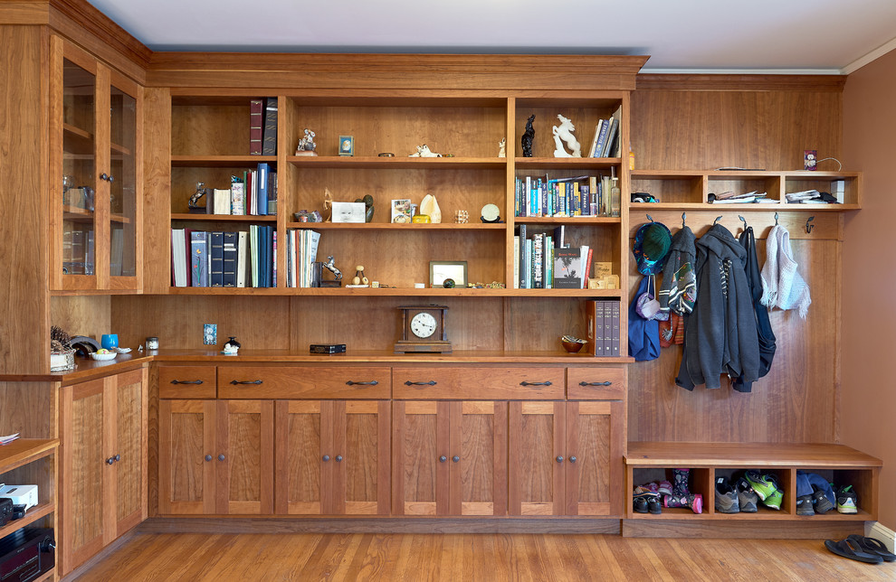 Ejemplo de armario vestidor unisex clásico renovado de tamaño medio con armarios estilo shaker, puertas de armario de madera oscura, suelo de madera en tonos medios y suelo marrón