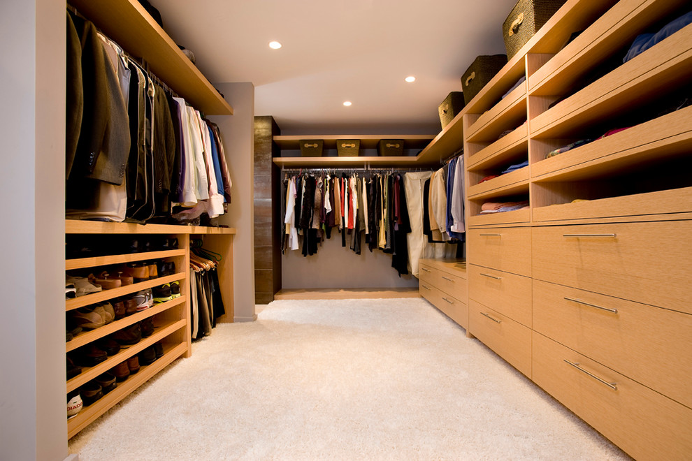 Modelo de vestidor unisex clásico renovado grande con armarios con paneles lisos, puertas de armario de madera clara, moqueta y suelo beige