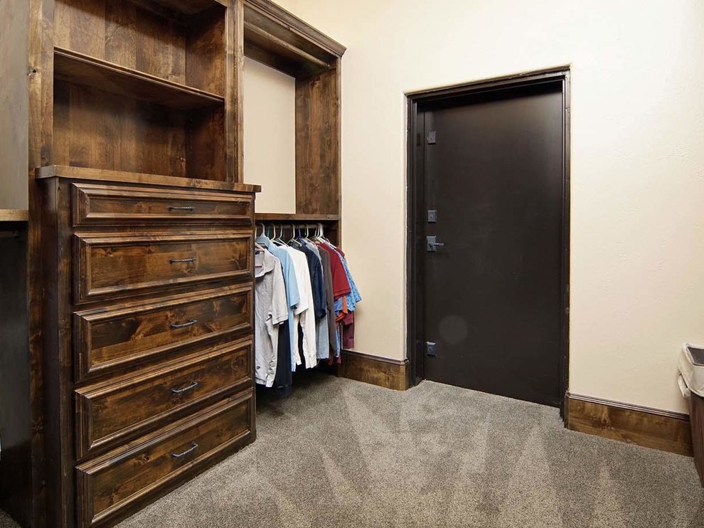 Inspiration for a large rustic gender neutral walk-in wardrobe in Dallas with recessed-panel cabinets, medium wood cabinets and carpet.