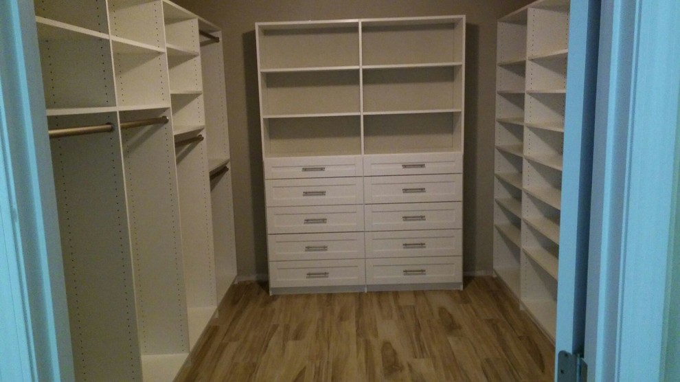 Diseño de armario vestidor unisex de tamaño medio con armarios estilo shaker, puertas de armario blancas y suelo de madera clara