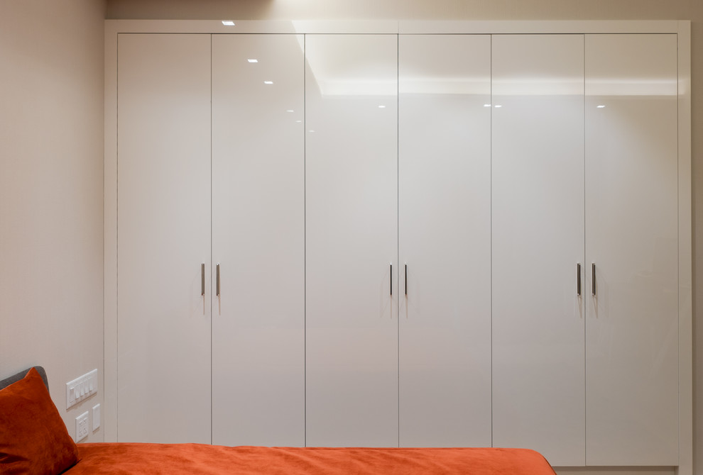 Inspiration pour un petit placard dressing minimaliste neutre avec un placard à porte plane et des portes de placard blanches.