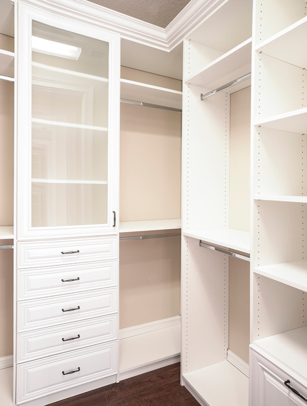 Foto de armario vestidor unisex clásico de tamaño medio con armarios abiertos, puertas de armario blancas y suelo de madera oscura