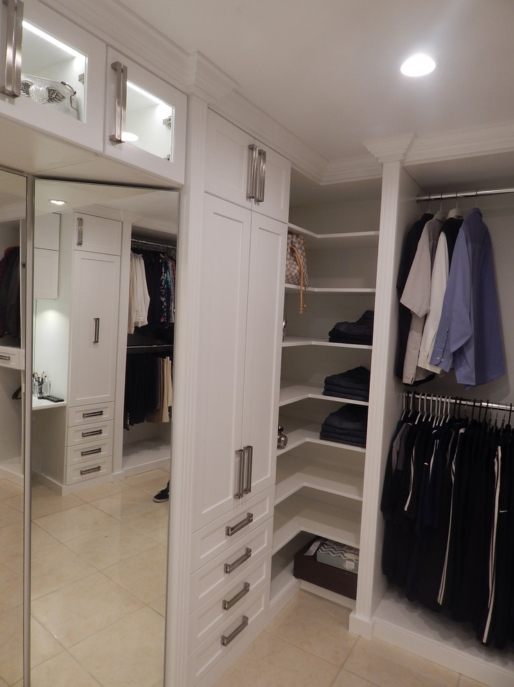 Cette image montre un grand dressing room design pour une femme avec un placard à porte shaker et des portes de placard blanches.