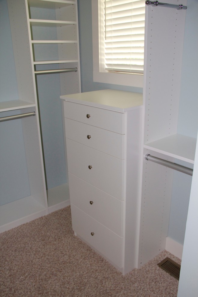 Imagen de armario unisex pequeño con puertas de armario blancas y moqueta