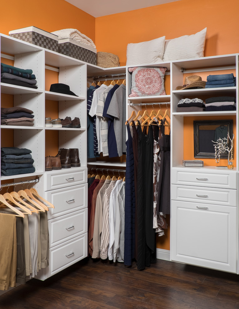 Imagen de armario y vestidor unisex tradicional con armarios con paneles con relieve, puertas de armario blancas y suelo de madera oscura