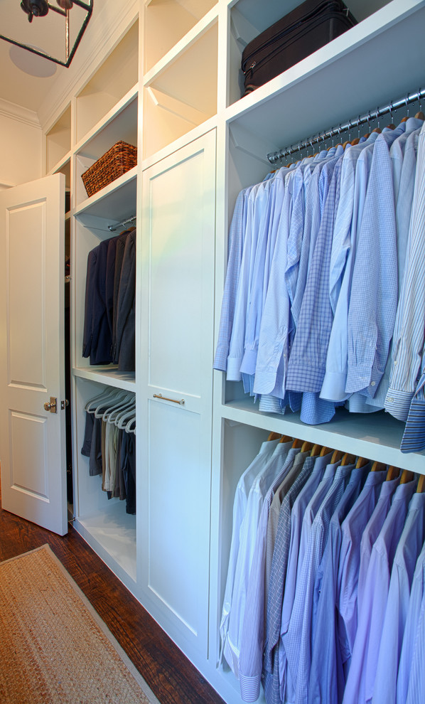 Example of a mid-sized classic men's medium tone wood floor walk-in closet design in Dallas with recessed-panel cabinets and white cabinets