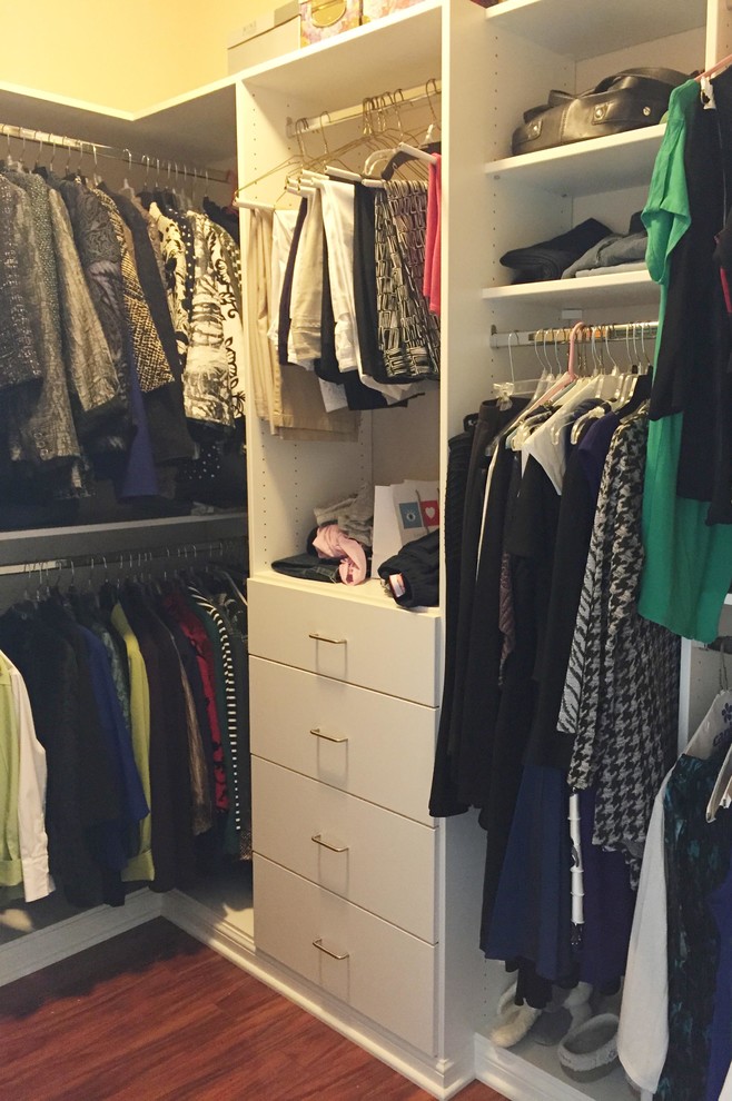 Ejemplo de armario vestidor unisex clásico renovado de tamaño medio con armarios con paneles lisos, puertas de armario blancas y suelo de madera en tonos medios