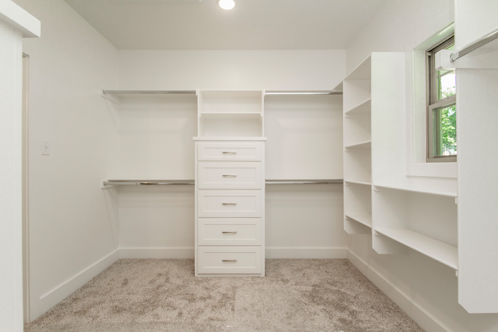 Inspiration for a large traditional gender neutral walk-in wardrobe in Little Rock with recessed-panel cabinets, white cabinets, carpet and grey floors.
