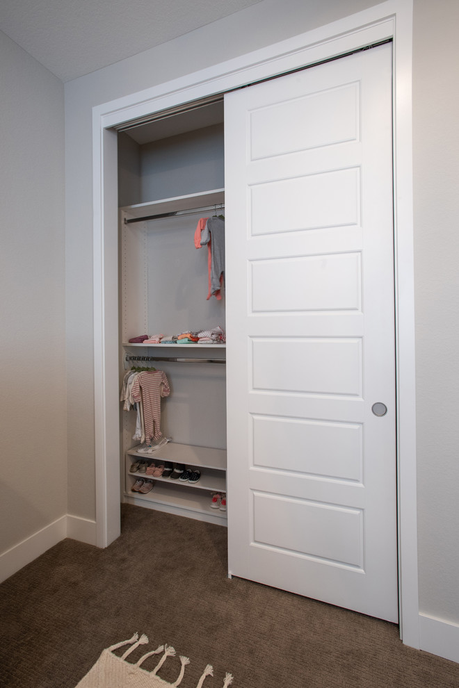 Foto di un piccolo armadio o armadio a muro unisex minimal con moquette e pavimento beige