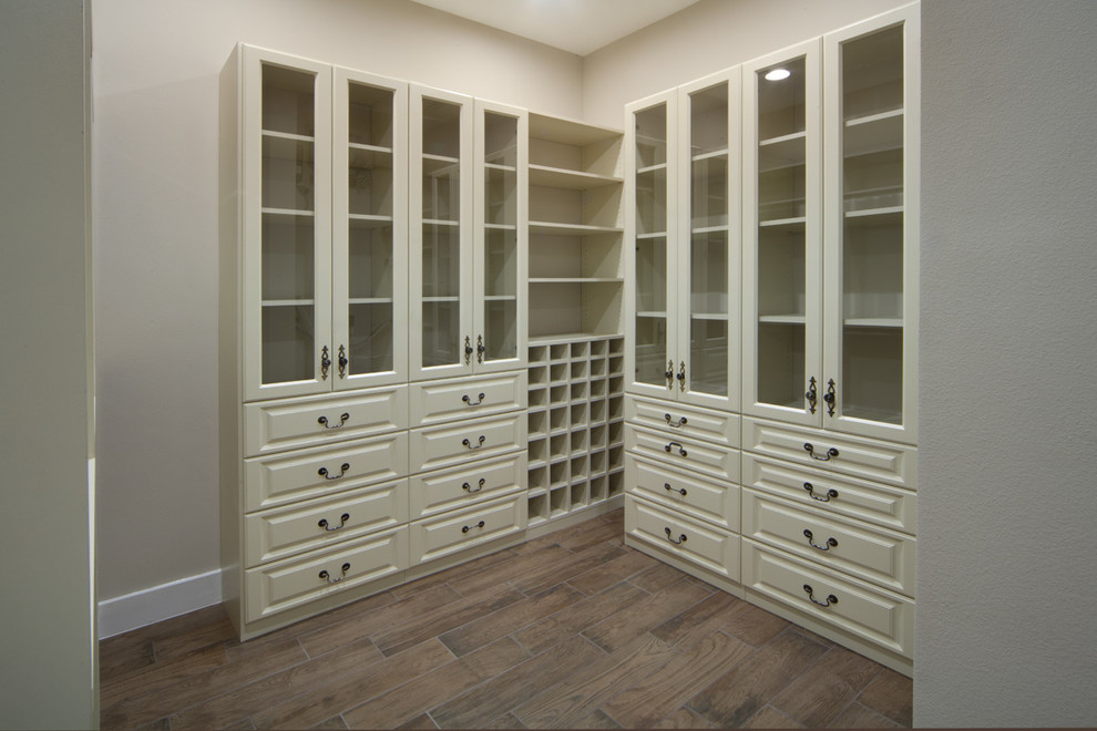 Ejemplo de armario vestidor unisex clásico renovado grande con armarios con paneles con relieve, puertas de armario blancas y suelo de baldosas de cerámica