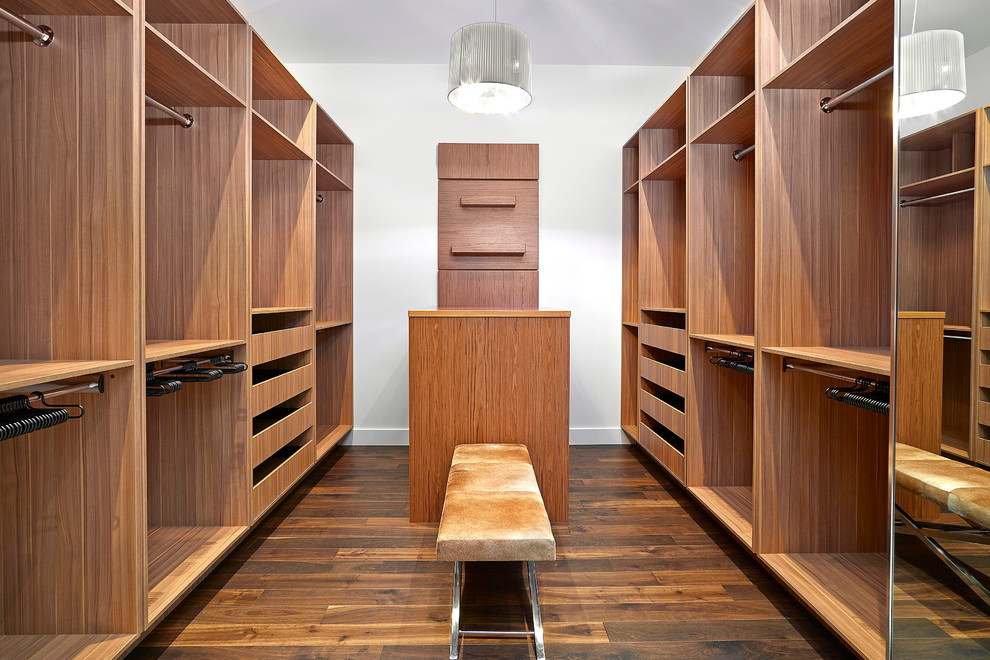 Ejemplo de armario vestidor unisex contemporáneo grande con armarios abiertos, puertas de armario de madera oscura y suelo de madera oscura
