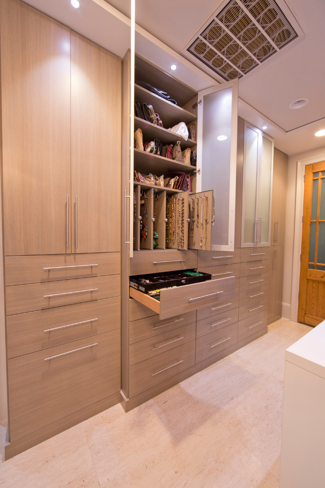 Example of a huge minimalist women's travertine floor dressing room design in New Orleans with flat-panel cabinets and gray cabinets