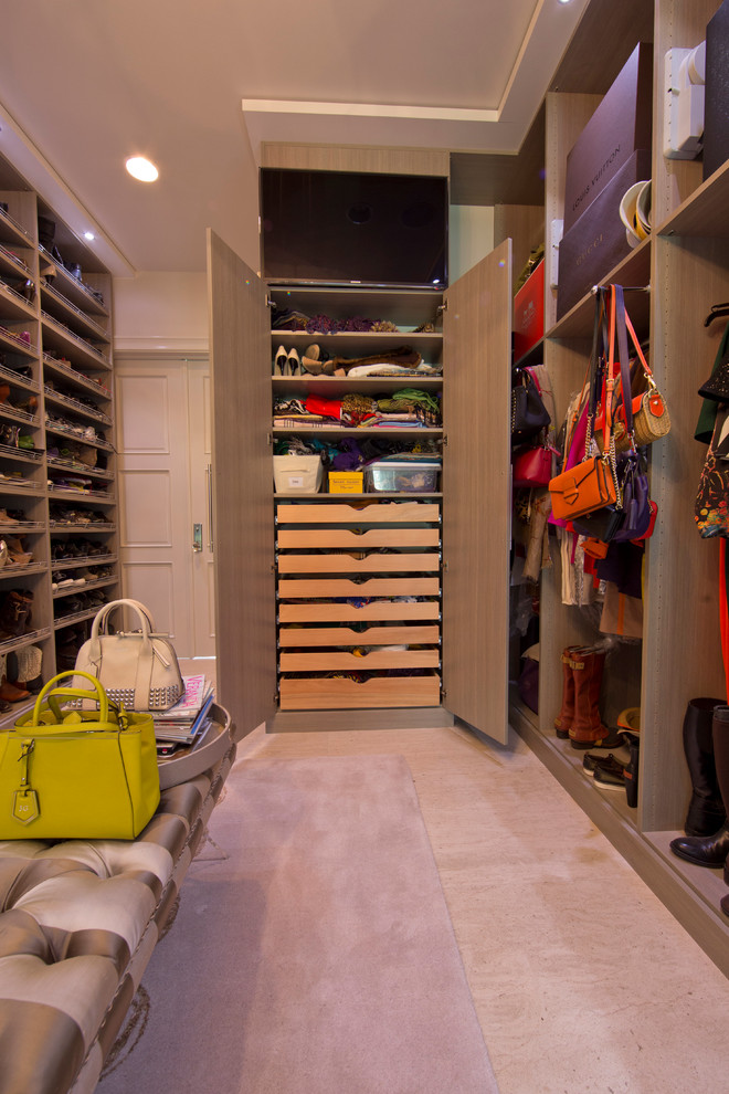 Idee per un ampio spazio per vestirsi per donna minimalista con ante lisce, pavimento in travertino e ante beige