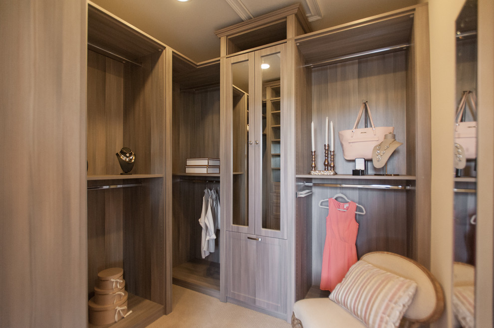 This is an example of a medium sized classic walk-in wardrobe for women in Jacksonville with open cabinets, medium wood cabinets and carpet.