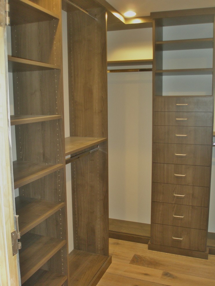 Walk-in closet - small craftsman men's light wood floor and brown floor walk-in closet idea in Los Angeles with flat-panel cabinets and dark wood cabinets