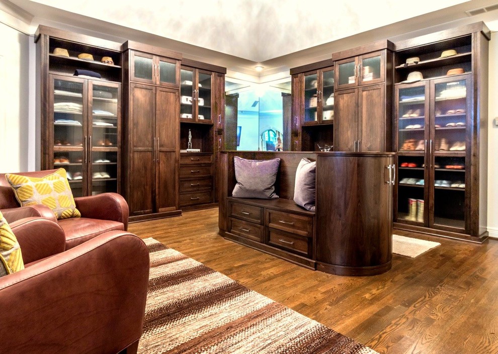 Cette image montre un très grand dressing room design en bois foncé avec un placard à porte shaker, un sol en bois brun et un sol marron.