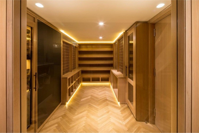 Example of a large arts and crafts gender-neutral light wood floor walk-in closet design in San Francisco with open cabinets and light wood cabinets