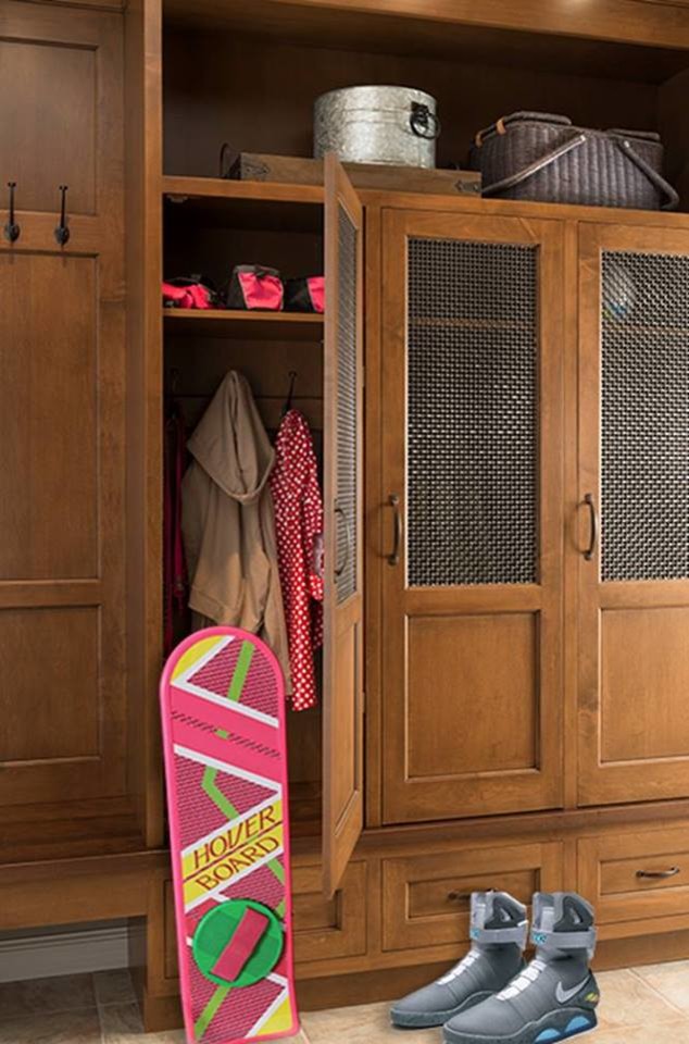 Elegant gender-neutral ceramic tile closet photo in Houston with light wood cabinets