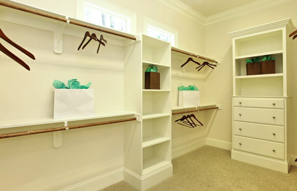 Inspiration for a large traditional gender neutral walk-in wardrobe in Raleigh with recessed-panel cabinets, white cabinets and carpet.