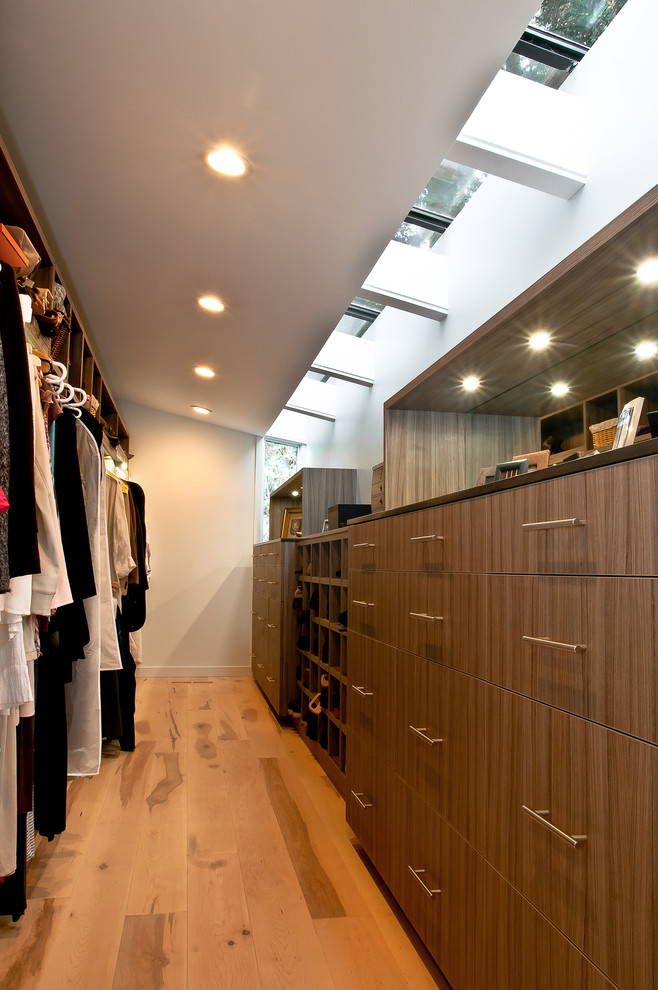 Imagen de armario vestidor contemporáneo con armarios con paneles lisos, puertas de armario de madera en tonos medios y suelo de madera en tonos medios