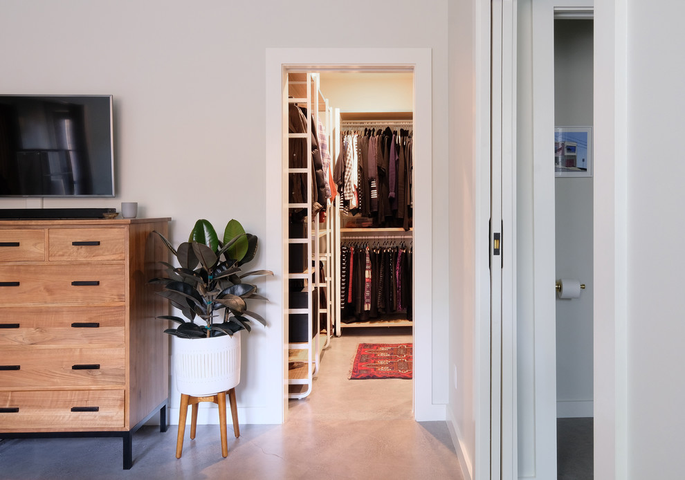 Exempel på ett mellanstort modernt walk-in-closet för könsneutrala, med öppna hyllor, skåp i ljust trä, betonggolv och grått golv
