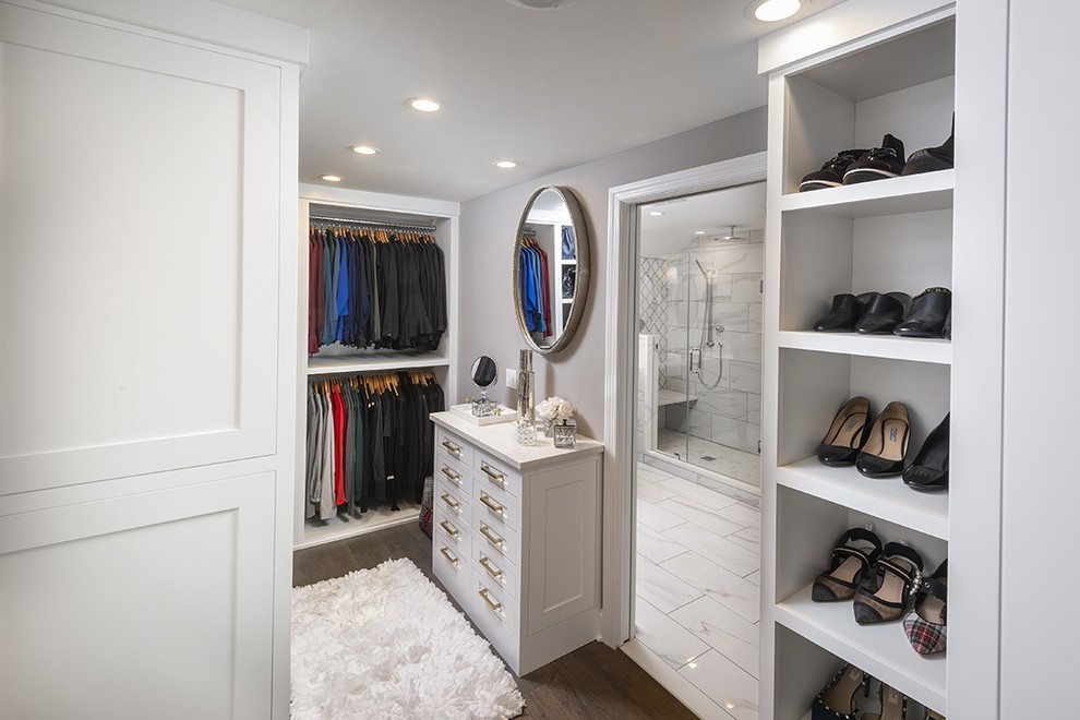 Foto de armario vestidor unisex clásico renovado pequeño con armarios con paneles empotrados, puertas de armario blancas, suelo de madera oscura y suelo marrón