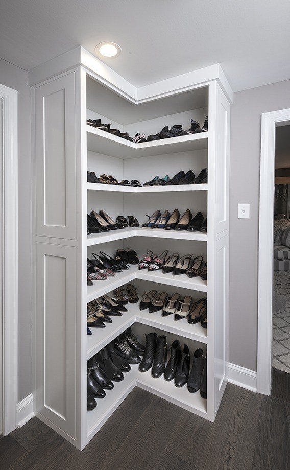 Klassisk inredning av ett litet walk-in-closet för könsneutrala, med luckor med infälld panel, vita skåp, mörkt trägolv och brunt golv