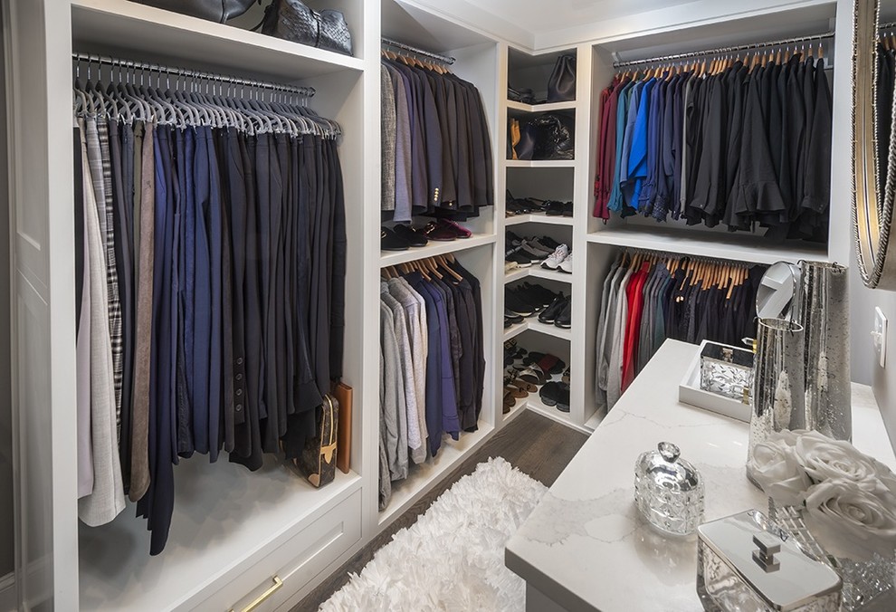 Imagen de armario vestidor unisex tradicional renovado pequeño con armarios con paneles empotrados, puertas de armario blancas, suelo de madera oscura y suelo marrón