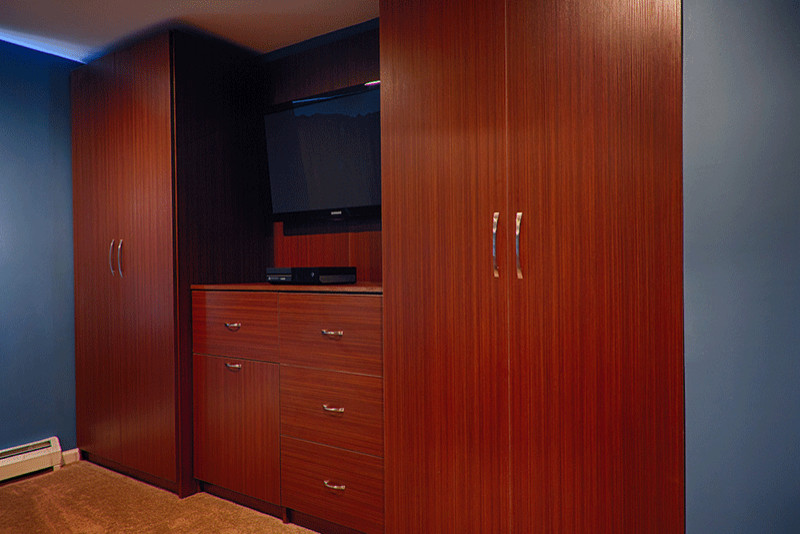 Cette image montre un placard dressing design en bois brun de taille moyenne pour un homme avec un placard à porte plane, moquette et un sol beige.