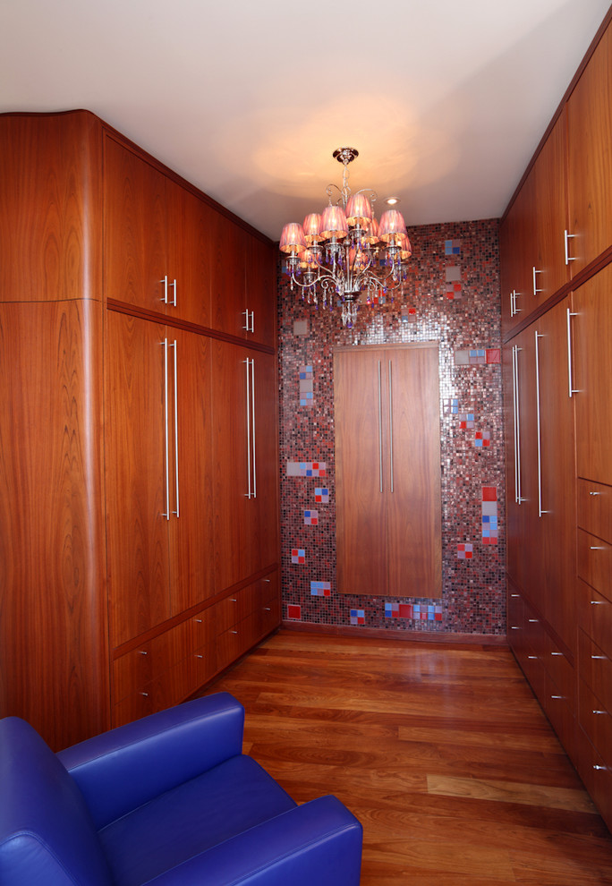 На фото: гардеробная комната в современном стиле с фасадами цвета дерева среднего тона с