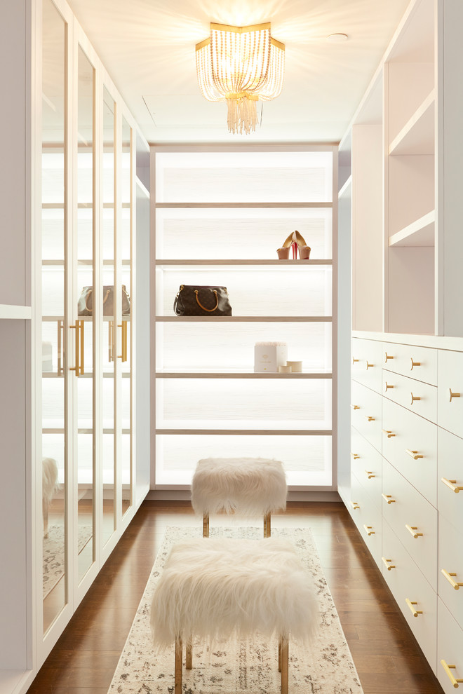 На фото: гардеробная комната в современном стиле с плоскими фасадами, белыми фасадами, темным паркетным полом и коричневым полом для женщин с
