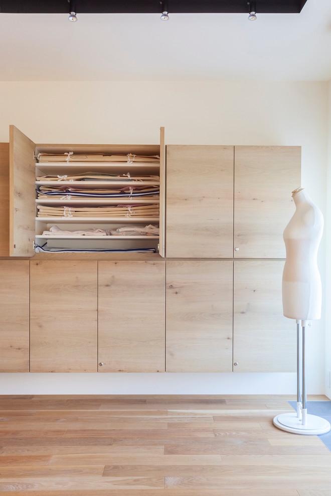 Cette photo montre un placard dressing en bois clair de taille moyenne pour une femme avec un placard à porte plane et un sol en bois brun.