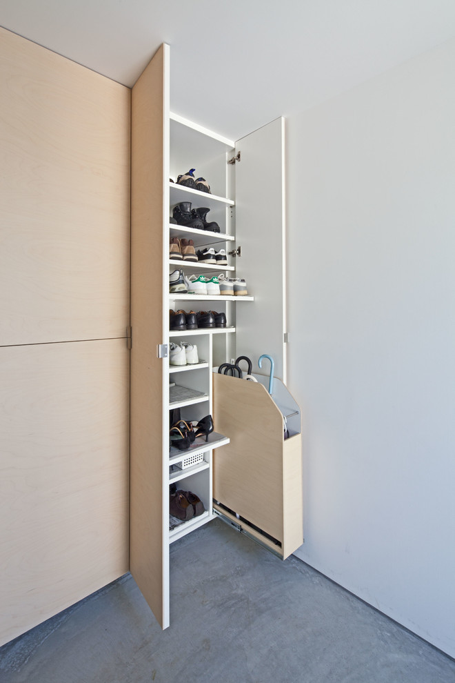 Imagen de armario contemporáneo con armarios con paneles lisos y puertas de armario de madera clara