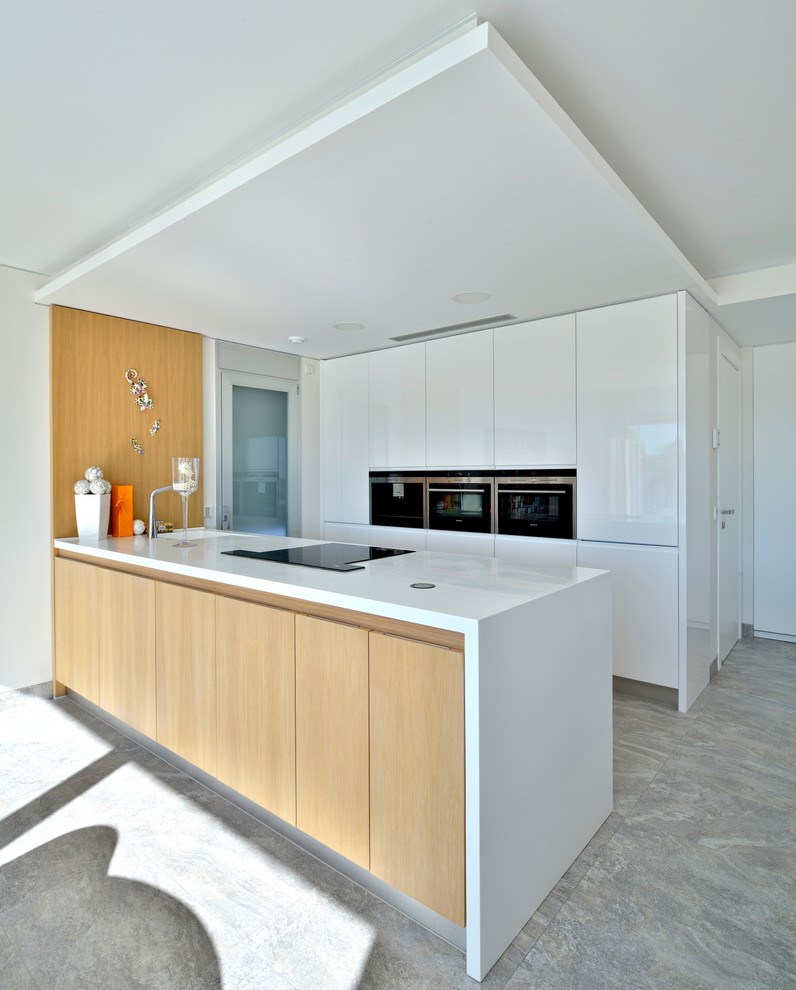 Open concept kitchen - mid-sized contemporary single-wall open concept kitchen idea in Alicante-Costa Blanca with a single-bowl sink, flat-panel cabinets, light wood cabinets, stainless steel appliances and a peninsula