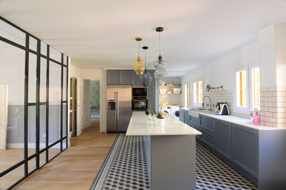 Exempel på ett avskilt, stort modernt linjärt kök, med luckor med upphöjd panel, grå skåp, vitt stänkskydd, stänkskydd i keramik, rostfria vitvaror, klinkergolv i keramik, en köksö och flerfärgat golv