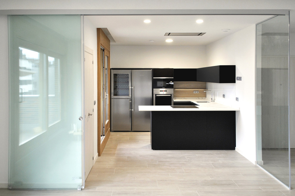 Inredning av ett modernt mellanstort kök, med en undermonterad diskho, släta luckor, svarta skåp, bänkskiva i kvarts, vitt stänkskydd, fönster som stänkskydd, rostfria vitvaror, klinkergolv i keramik, en halv köksö och brunt golv