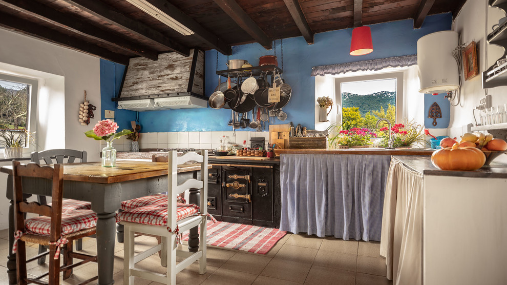Große Eklektische Wohnküche in L-Form mit Arbeitsplatte aus Holz, weißen Elektrogeräten, Keramikboden, Kücheninsel, beigem Boden, brauner Arbeitsplatte und Küchenrückwand in Weiß in Bilbao